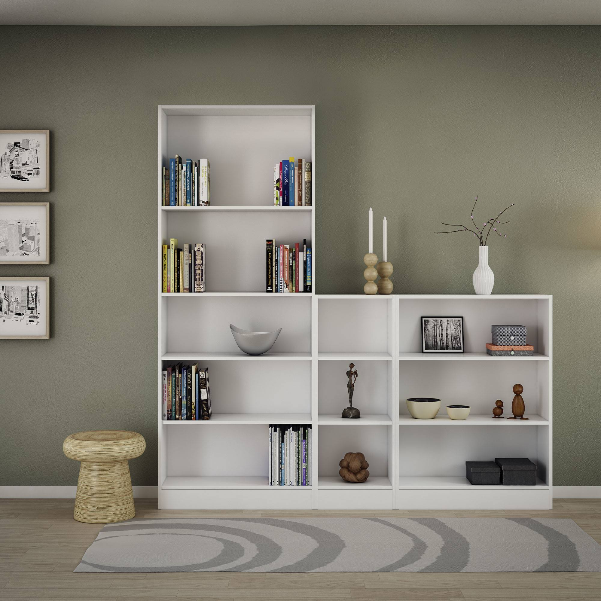 Una estantería blanca con libros, decoración y un taburete. Una alfombra gris está en el suelo de madera. La pared es verde oliva.