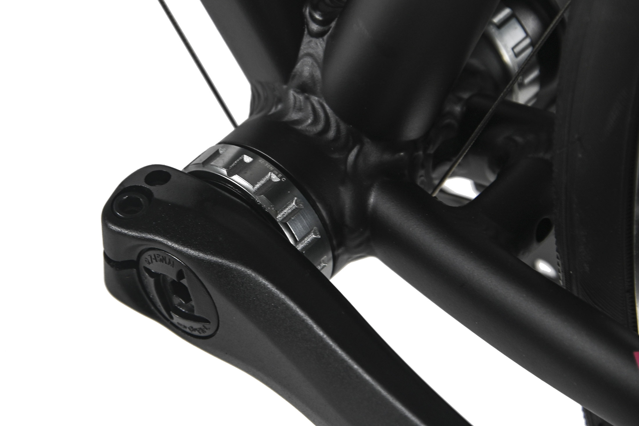 Nahaufnahme einer schwarzen Fahrradkurbel und eines Rahmens. Silberne Komponenten und ein schwarzer Reifen sind ebenfalls zu sehen.