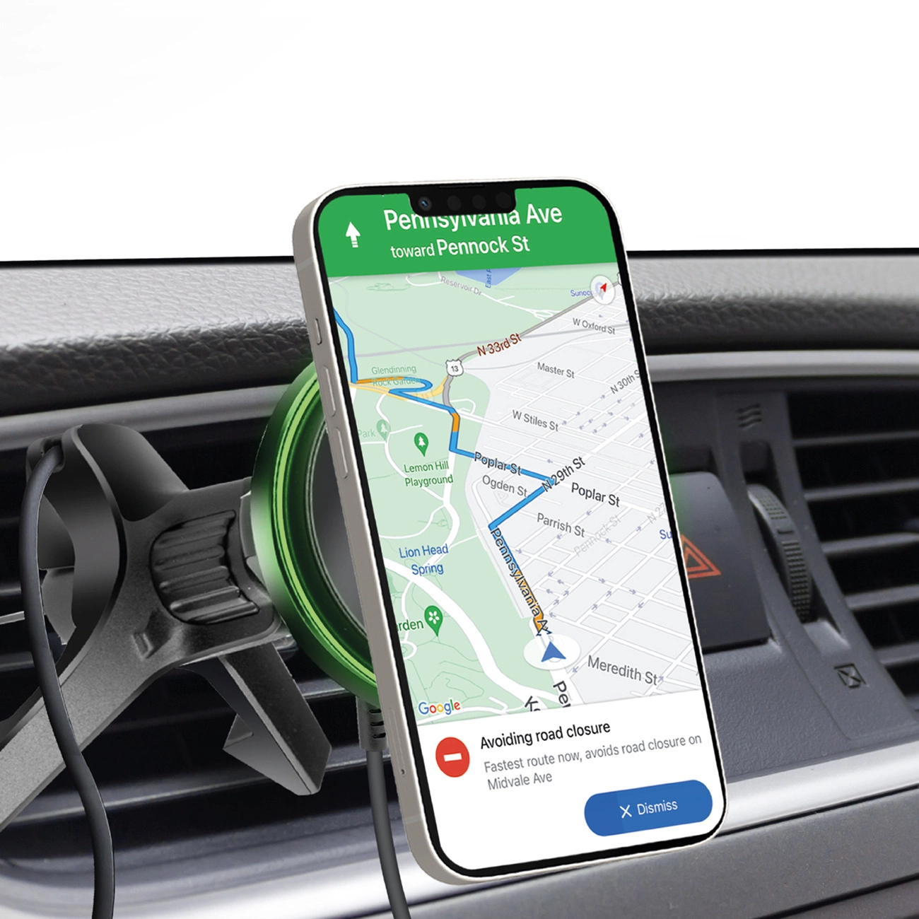 Un telefono mostra una mappa con indicazioni, montato su una presa d'aria dell'auto. Viene segnalata una chiusura stradale. Il telefono è bianco con una fotocamera nera.