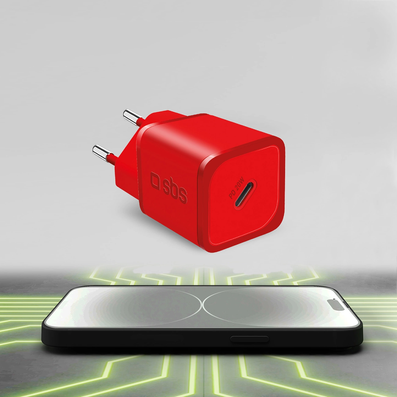 Un caricabatterie rosso e un telefono nero su una superficie con linee verdi. Il caricabatterie ha il logo 'sbs' e 'PD 20W'.