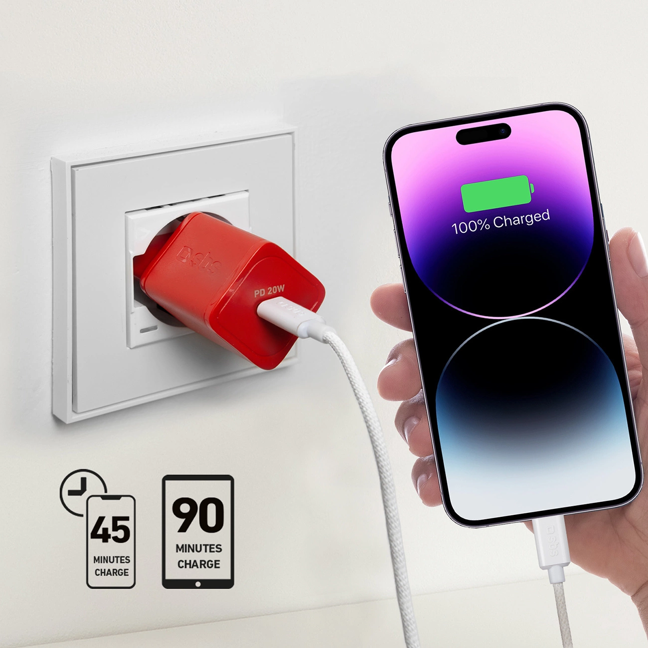 Un telefono si sta caricando. Un caricabatterie rosso è collegato al muro. Il telefono mostra 100% di carica.