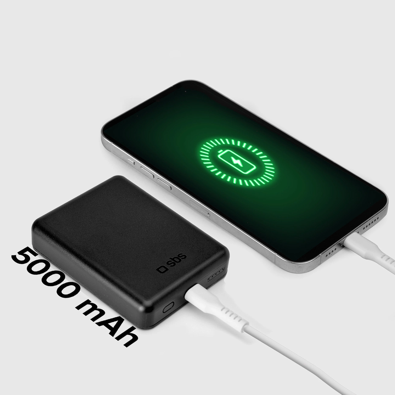 Czarny power bank jest podłączony do smartfona podczas ładowania. Telefon wyświetla zielony symbol ładowania. Widoczny tekst 5000 mAh.