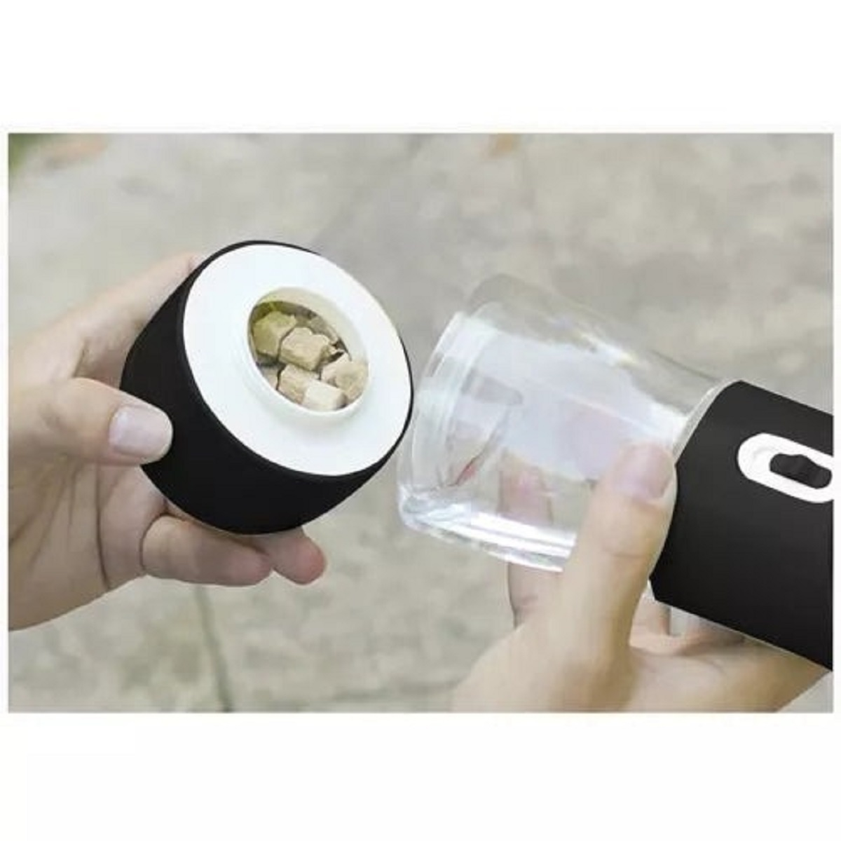 Una persona sostiene un recipiente blanco y negro con golosinas. Hay un recipiente de vidrio transparente cerca. El fondo está borroso.