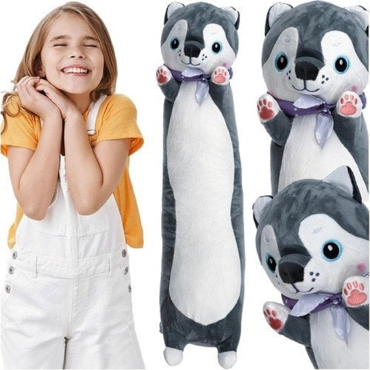 Una niña sonriente con un mono blanco y una camisa naranja está de pie junto a tres juguetes de peluche de husky. Los juguetes tienen ojos azules y cintas moradas.