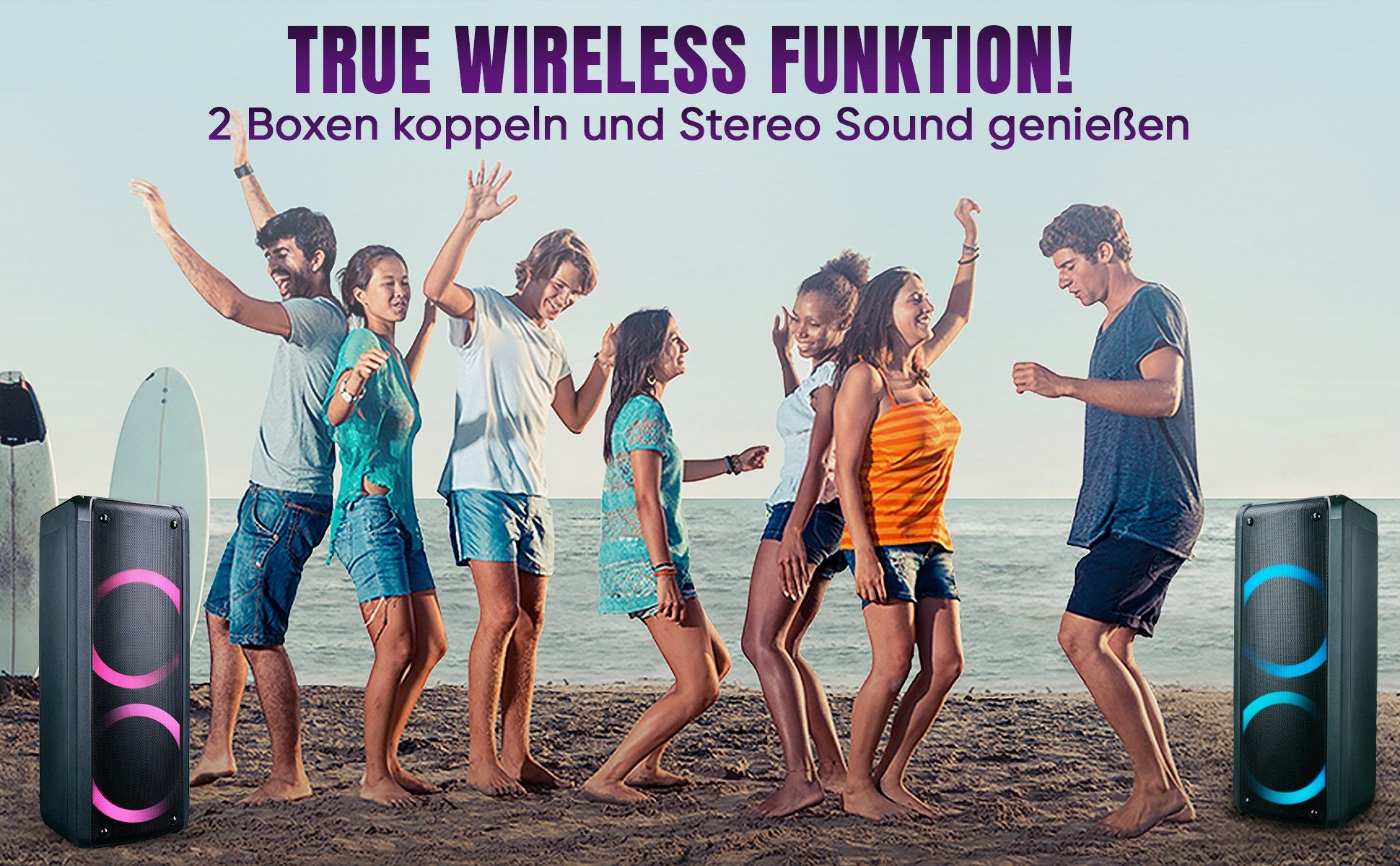 Gruppe von Menschen tanzt am Strand. Zwei Lautsprecher flankieren die Gruppe. Der Himmel ist blau. Text oben: True Wireless Funktion!