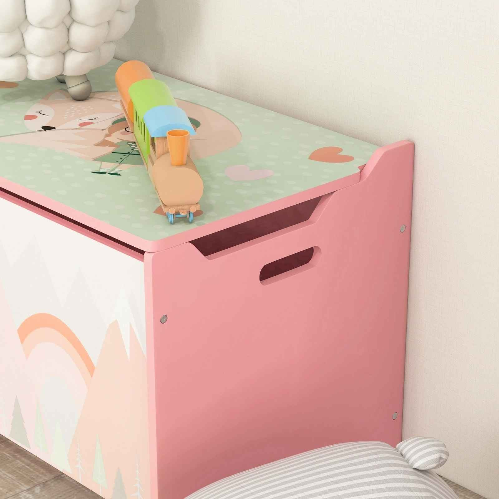 Rosa Spielzeugkiste mit einem Spielzeugzug darauf. Die Kiste hat ein Berg- und Regenbogen-Design.