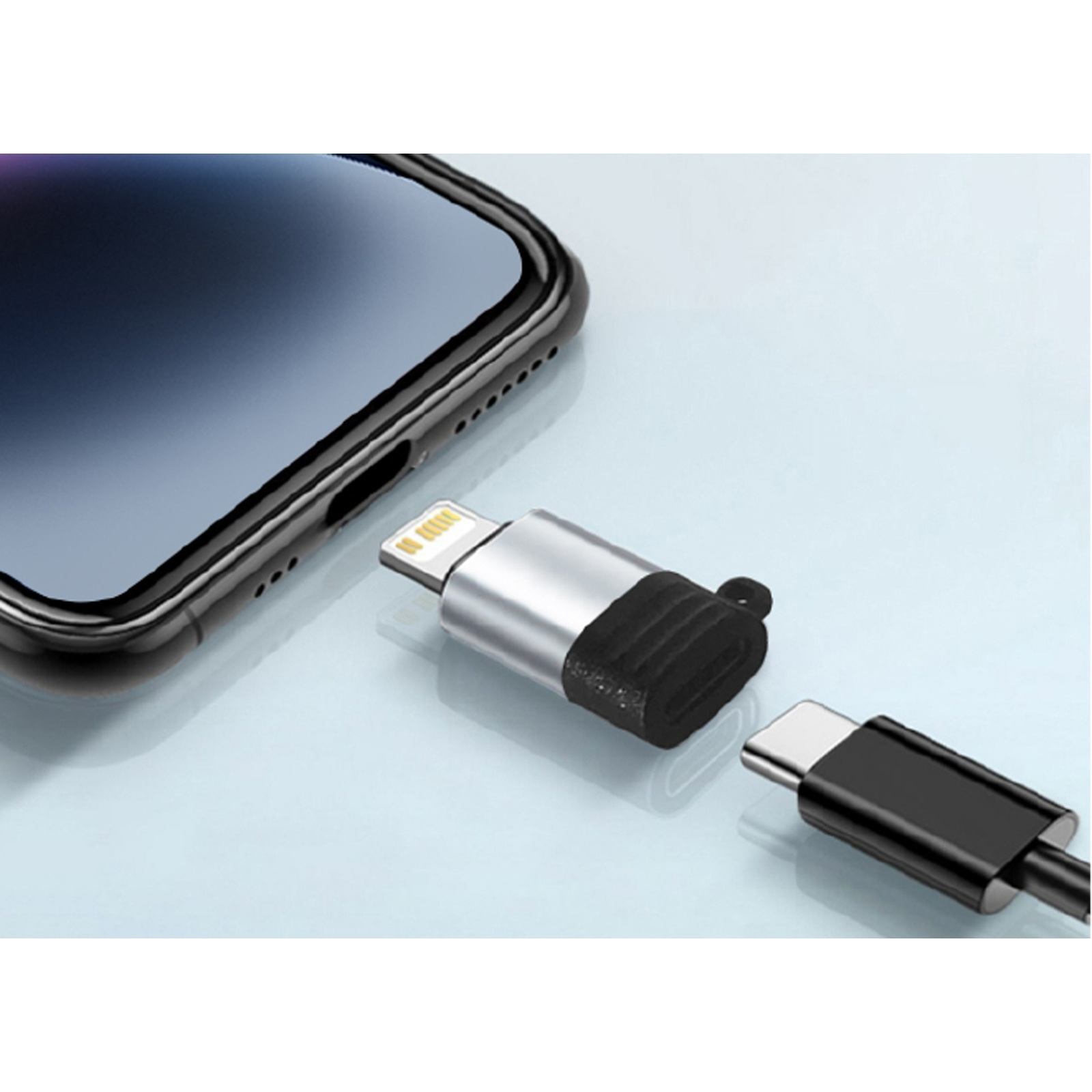 Un iPhone con un adaptador de puerto lightning, un cable USB-C y un adaptador. El adaptador tiene un puerto lightning y USB-C.