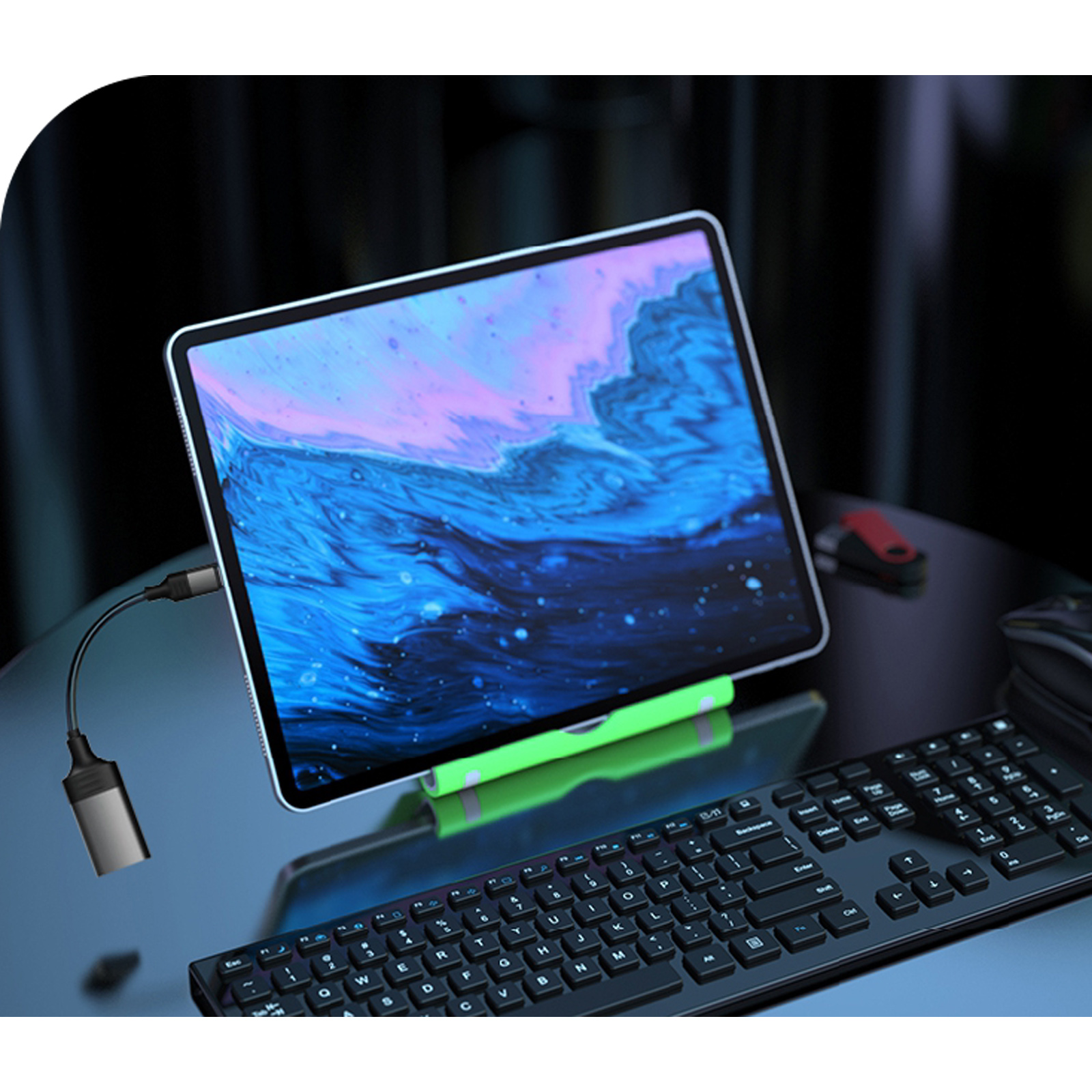 Una tableta con pantalla vibrante se apoya en un soporte. Debajo hay un teclado y un cable con un adaptador conectado.
