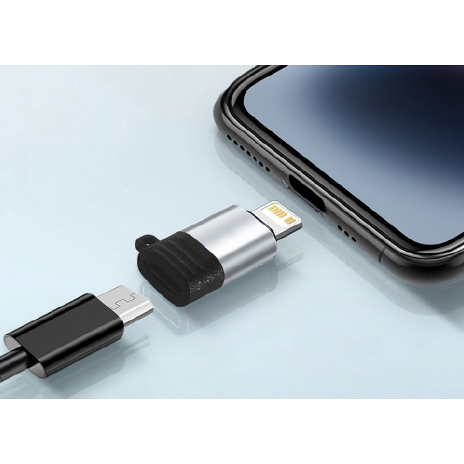 Un teléfono y un adaptador plateado con un cable negro. El adaptador está conectado al teléfono.
