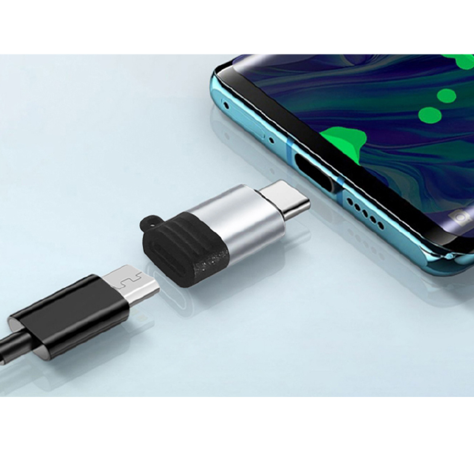 Un teléfono y un adaptador plateado con un extremo negro están sobre una superficie azul claro. Un cable negro está conectado.