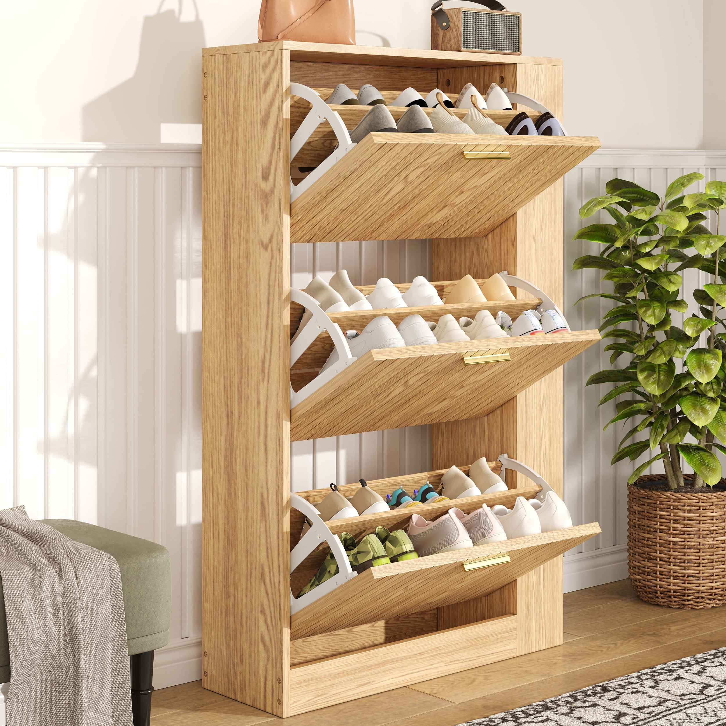 Schuhregal aus Holz mit drei offenen Regalen voller Schuhe. Rechts eine Pflanze, links ein Hocker mit Decke.