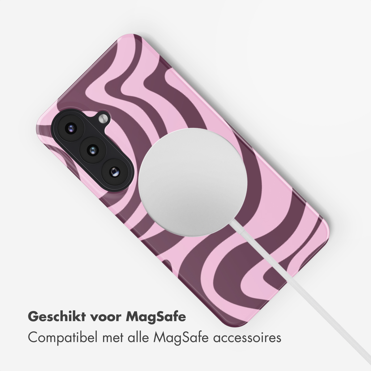 Een telefoonhoesje met een roze en paars wervelontwerp. Een witte, cirkelvormige MagSafe-oplader is bevestigd, met een witte kabel.