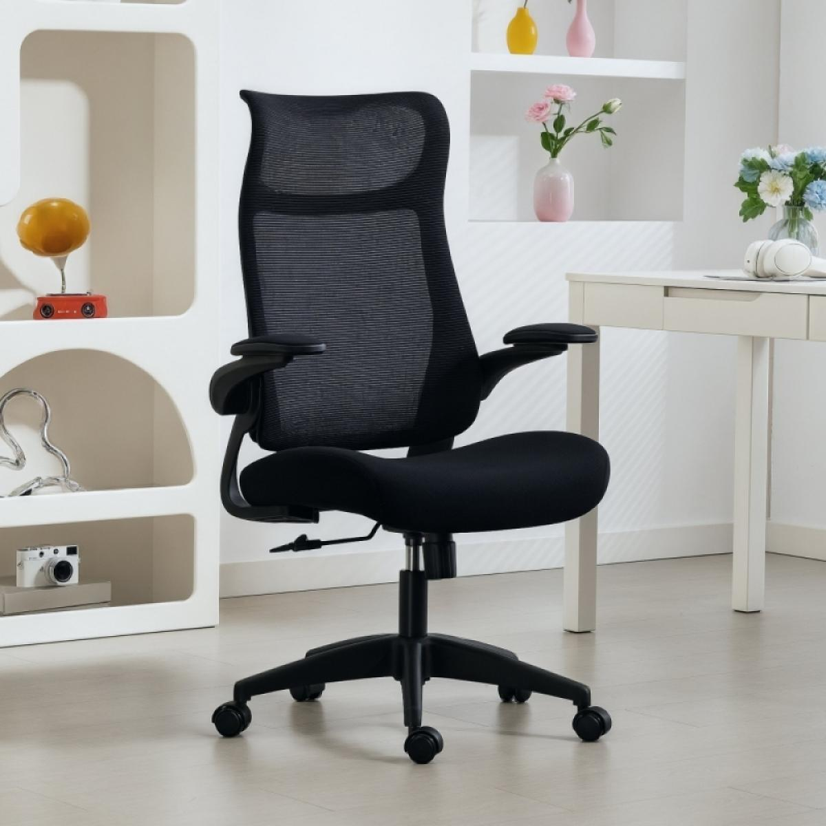 Schwarzer Bürostuhl in einem hellen Raum. Der Stuhl steht vor einem weißen Schreibtisch und einem Regal mit Dekorationen.