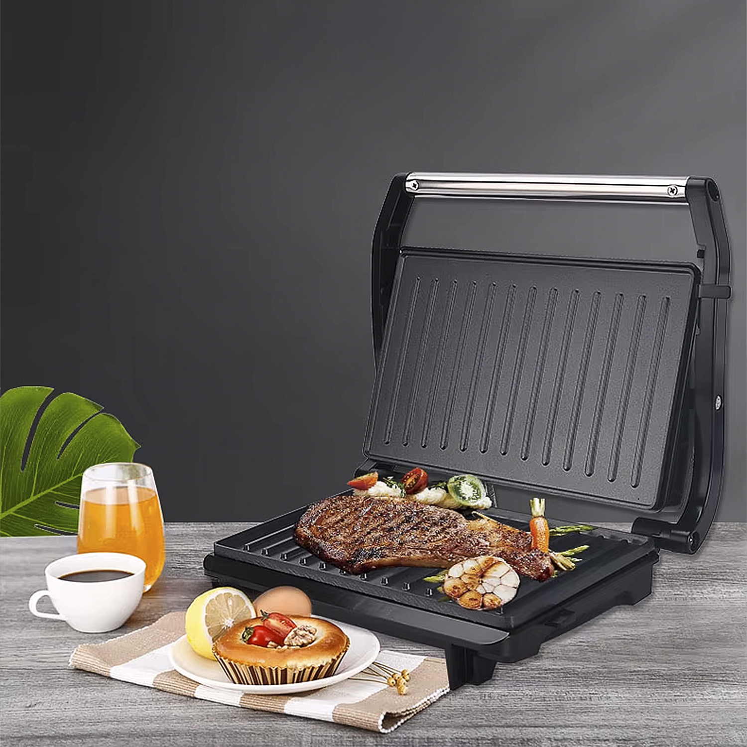 Una parrilla con bistec, verduras y un pastel. También hay bebidas y otros alimentos en la mesa de madera.