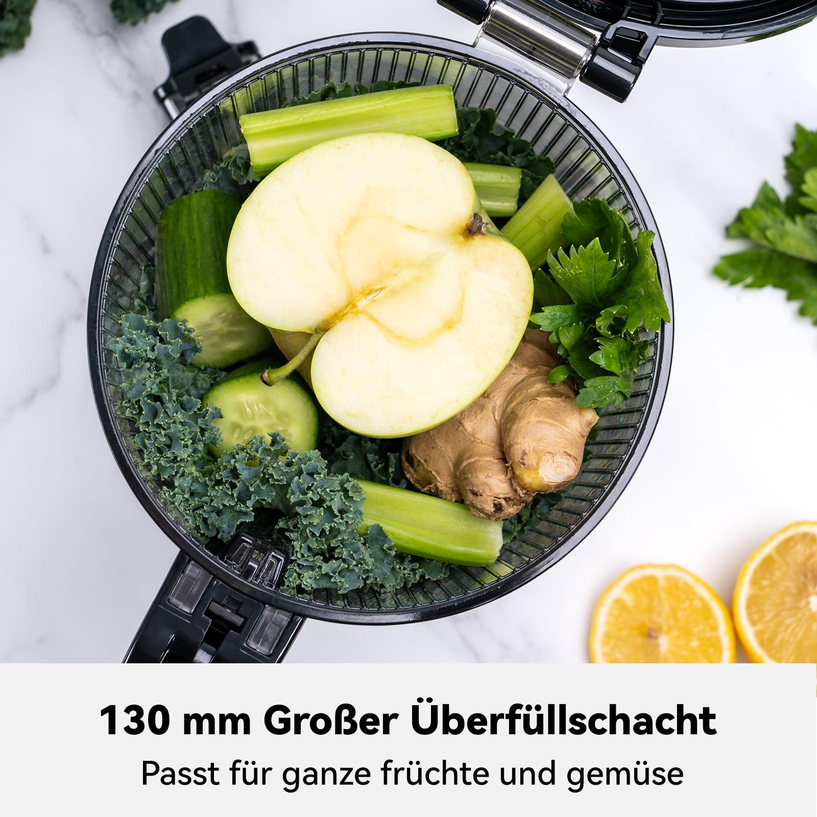 Ein Saftkorb gefüllt mit Apfel, Gurke, Sellerie, Ingwer und Grünkohl. Zwei Zitronenhälften sind rechts unten.