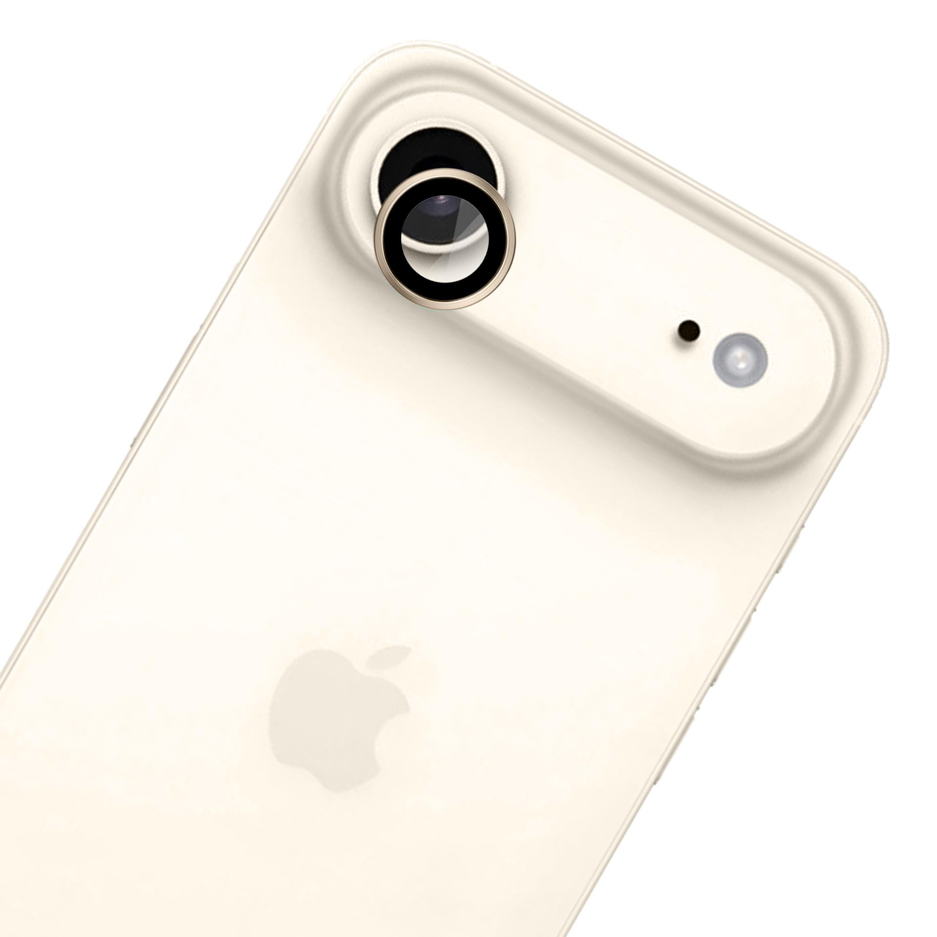 Primo piano di un telefono color crema con un rigonfiamento della fotocamera. Il logo Apple è visibile. L'obiettivo ha un anello dorato.