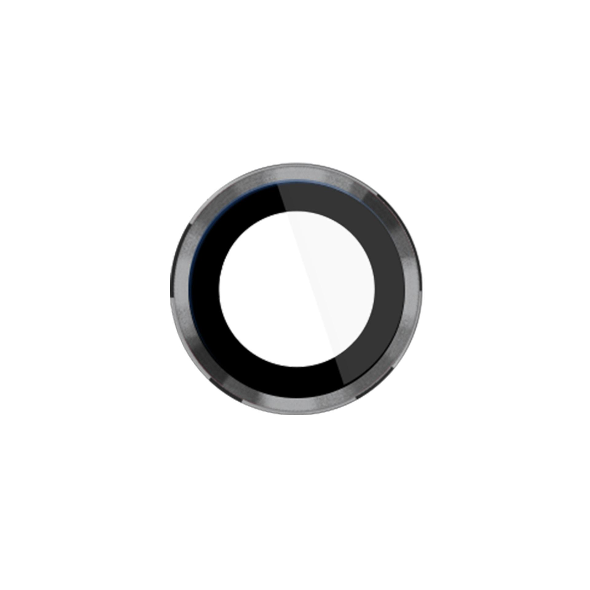 Un oggetto circolare, probabilmente un copriobiettivo, con un cerchio bianco centrale e bordi neri e argentati.