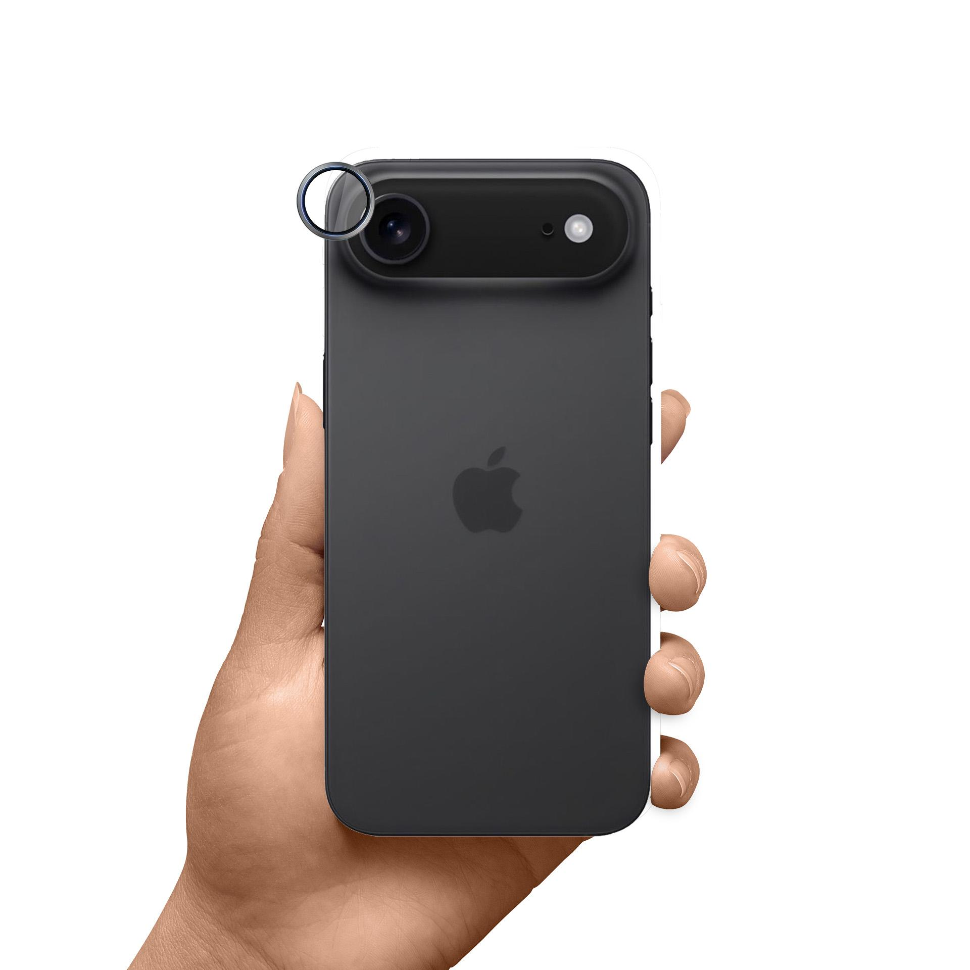 Dłoń trzymająca czarnego iPhone'a. Telefon ma aparat i lampę błyskową. Logo Apple jest widoczne. Białe tło.