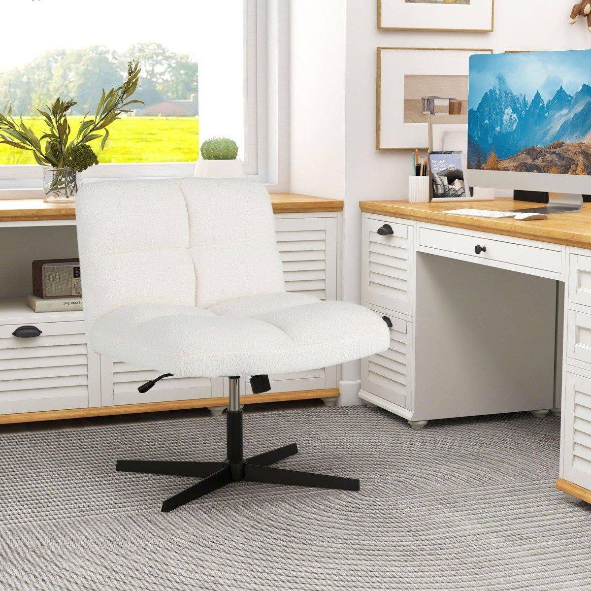 Una silla de oficina blanca se encuentra en una oficina en casa. Hay un escritorio con una computadora y una ventana con vista a un campo verde.