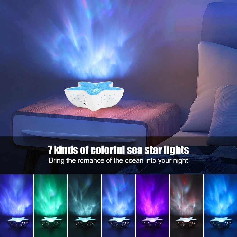 Ein sternförmiges Nachtlicht projiziert farbenfrohe Lichter im Ozean-Design. Es steht auf einem Nachttisch mit Bett und Kissen im Hintergrund.