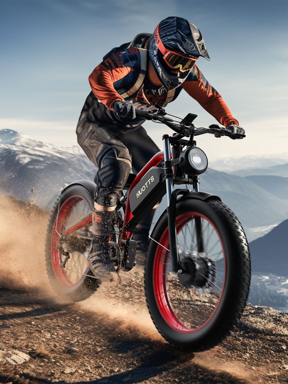 Una persona guida una bici elettrica rossa e nera su un sentiero di montagna. Il ciclista indossa un casco e abiti arancioni.