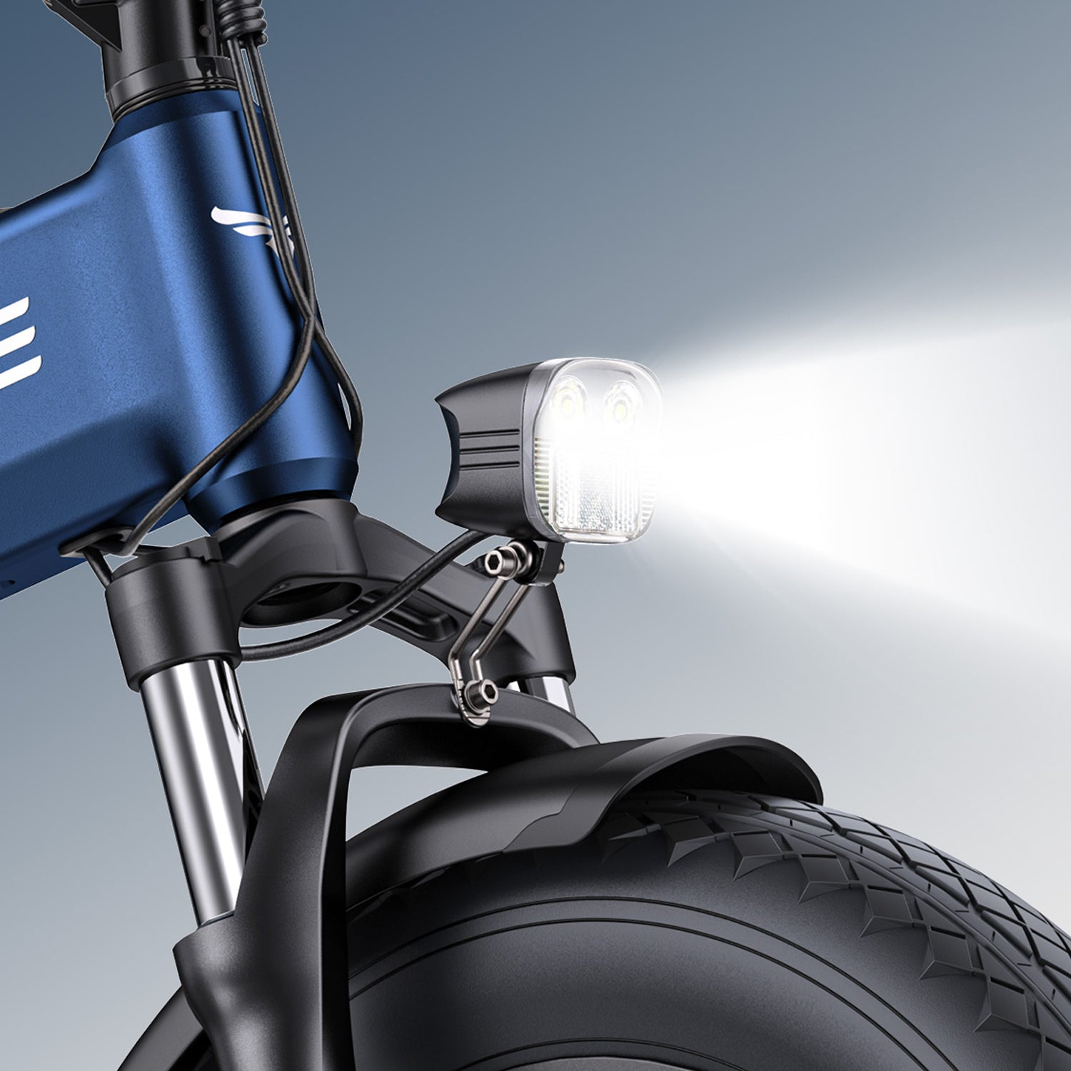Primer plano de una bicicleta eléctrica. El marco azul, los neumáticos negros y el faro brillante son visibles. La luz brilla intensamente.
