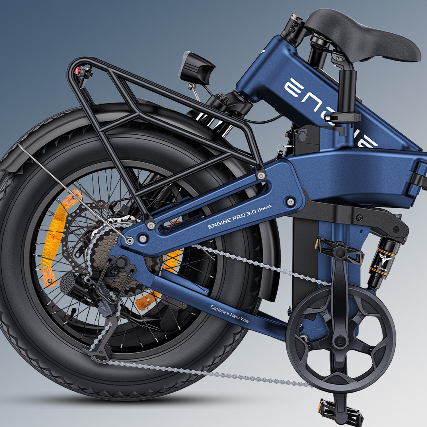 Bicicleta plegable azul Engine Pro 3.0 Boost. Llantas y portaequipajes negros. Reflectores naranjas. Cadena y engranajes visibles.