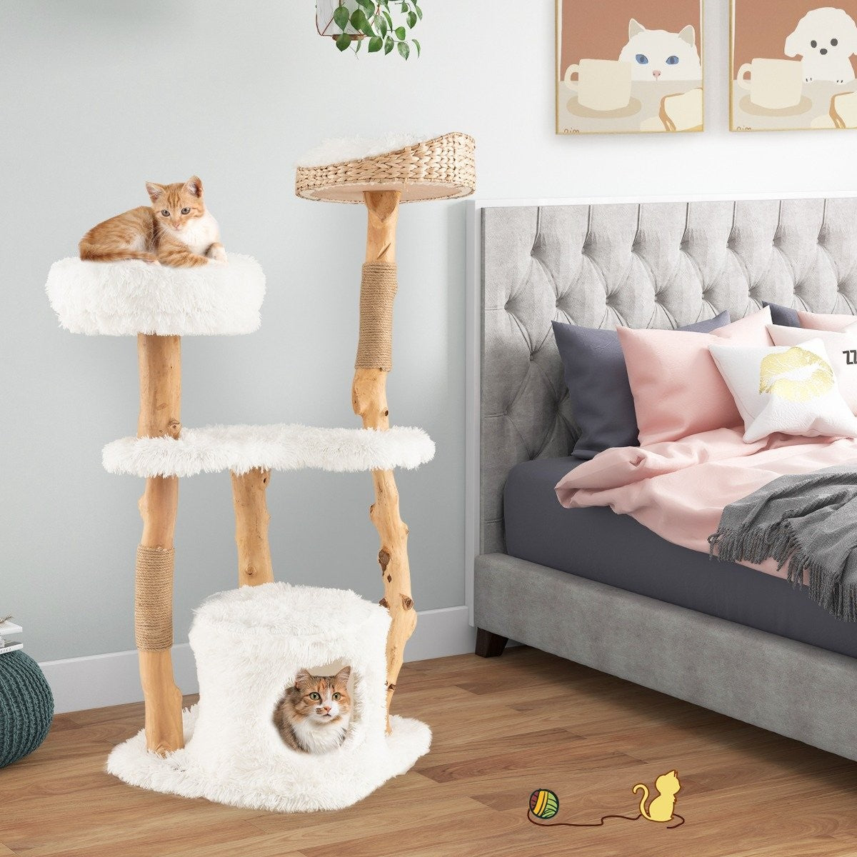 Un árbol para gatos con dos gatos. Un gato naranja arriba, uno dentro de la cueva. Una cama al fondo y un juguete para gatos en el suelo.
