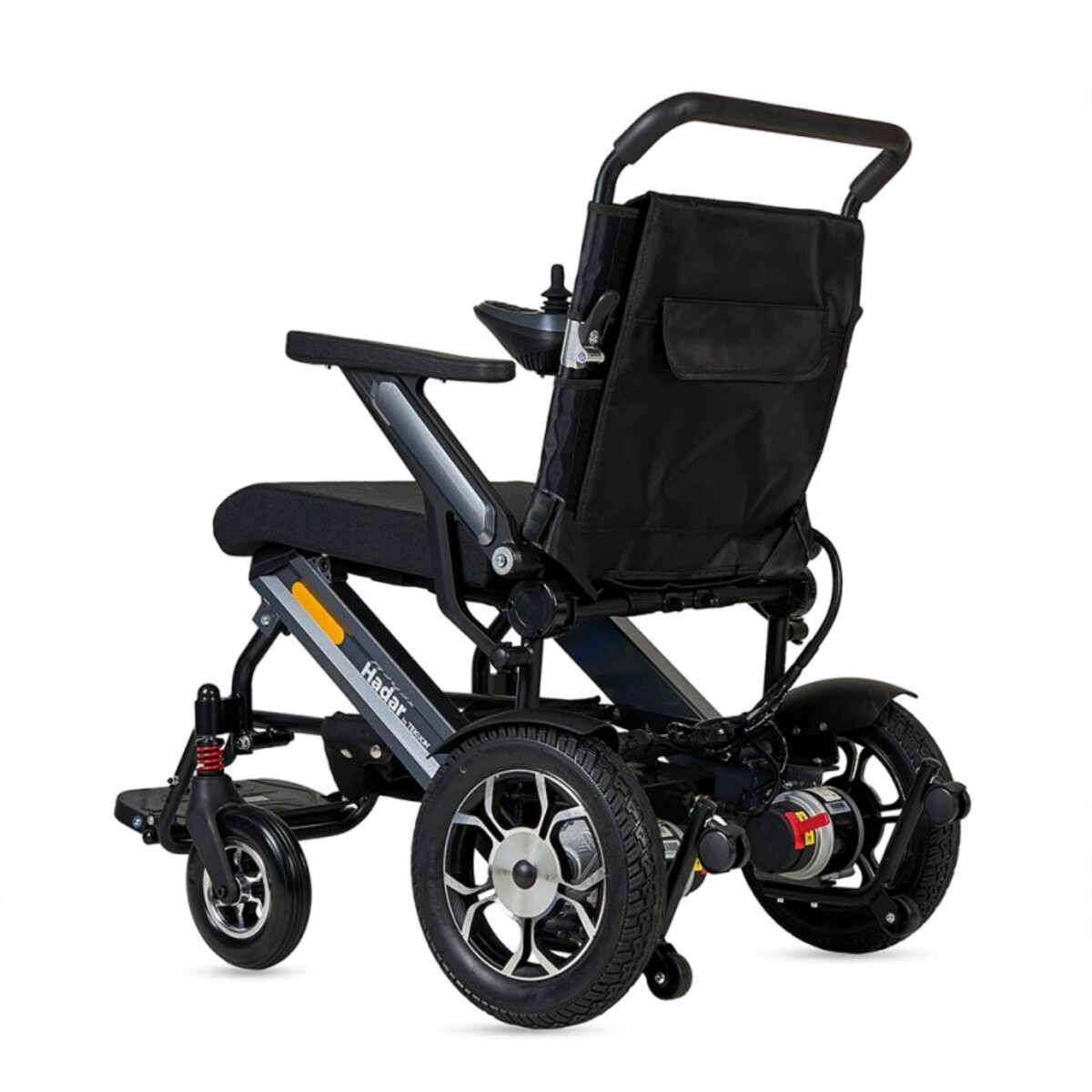Se muestra una silla de ruedas eléctrica negra y gris, tiene un asiento y respaldo negros, con un joystick y una pequeña bolsa de almacenamiento.