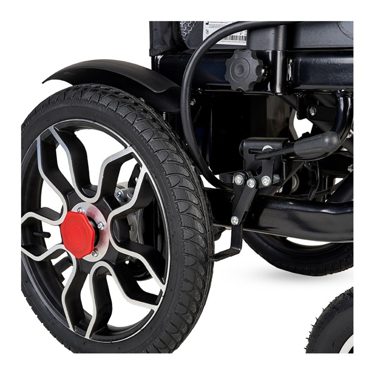 Primer plano de una rueda de silla de ruedas negra. El neumático es negro. La rueda tiene radios negros y plateados y una tapa central roja.