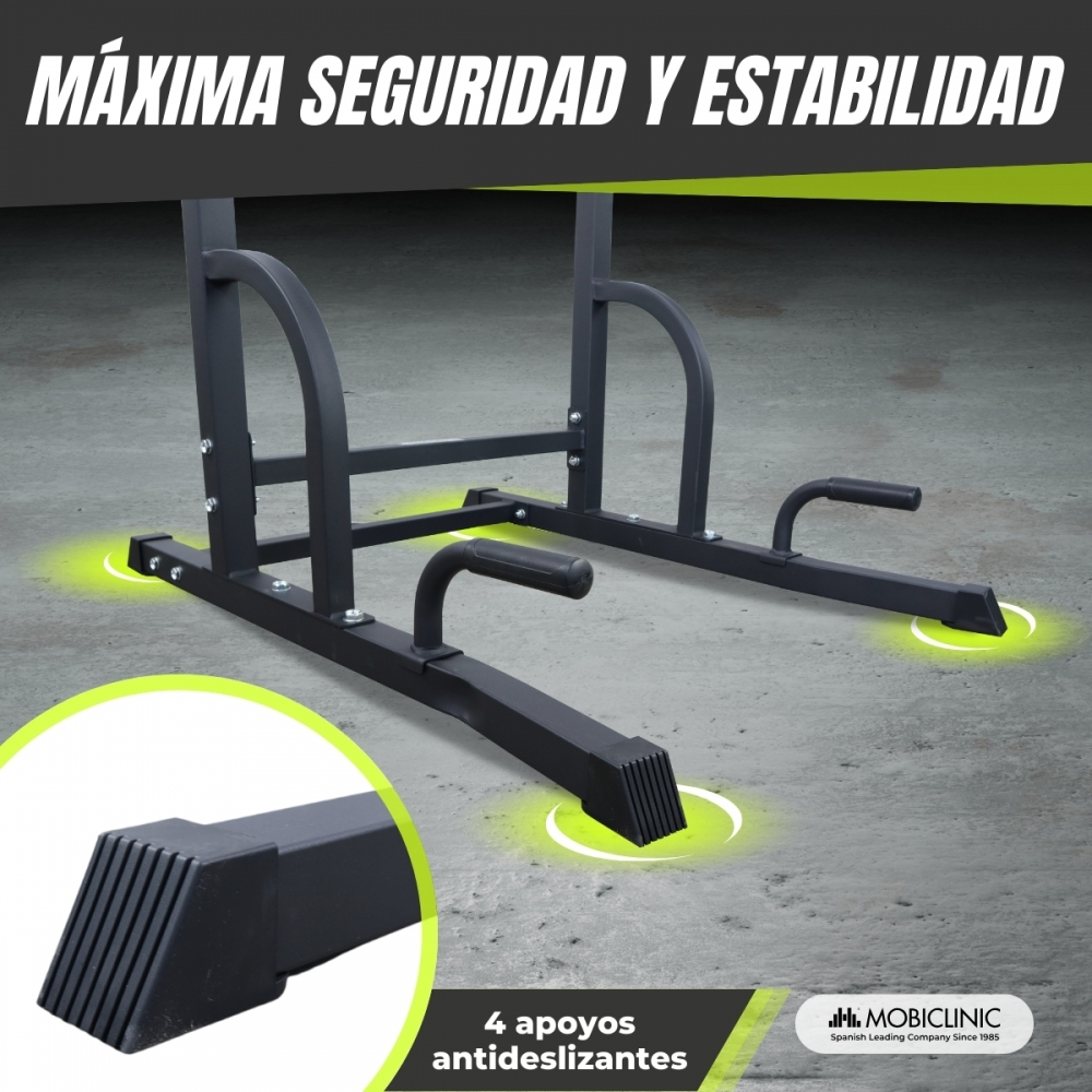 Equipo de fitness de metal negro sobre una superficie gris, con texto que indica seguridad y soportes antideslizantes.