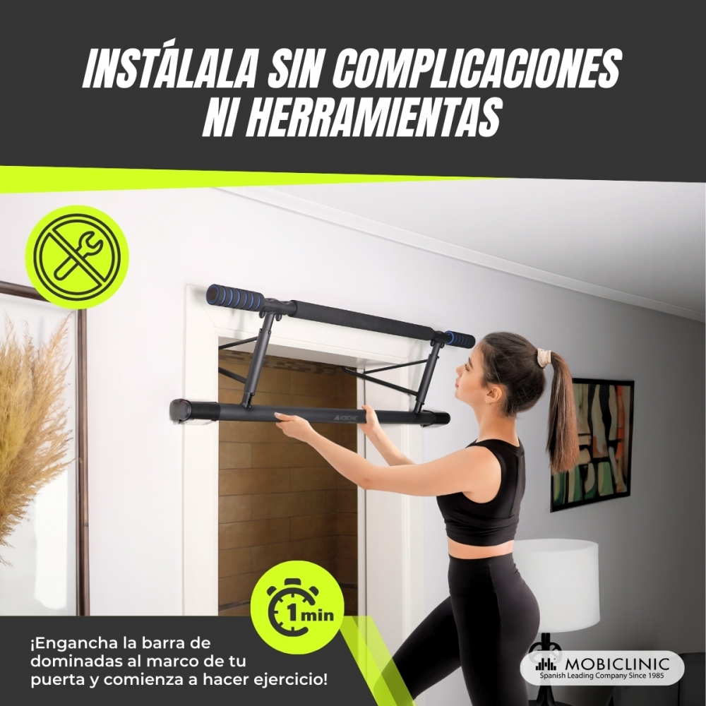Una mujer instala una barra de dominadas negra en un marco de puerta. El texto dice 'Instálala sin complicaciones ni herramientas'.