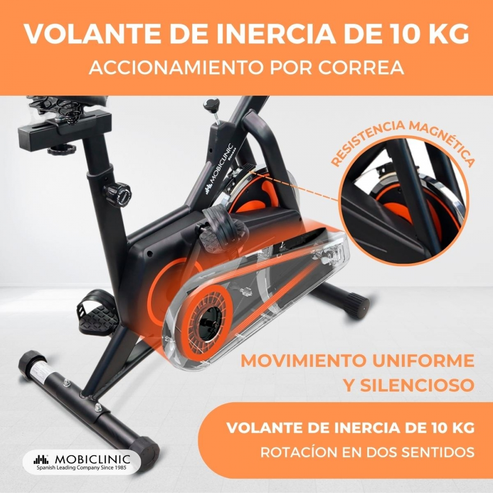 Bicicleta de ejercicio negra y naranja. El texto destaca la resistencia magnética y el movimiento uniforme y silencioso. Logotipo de la marca MOBICLINIC visible.