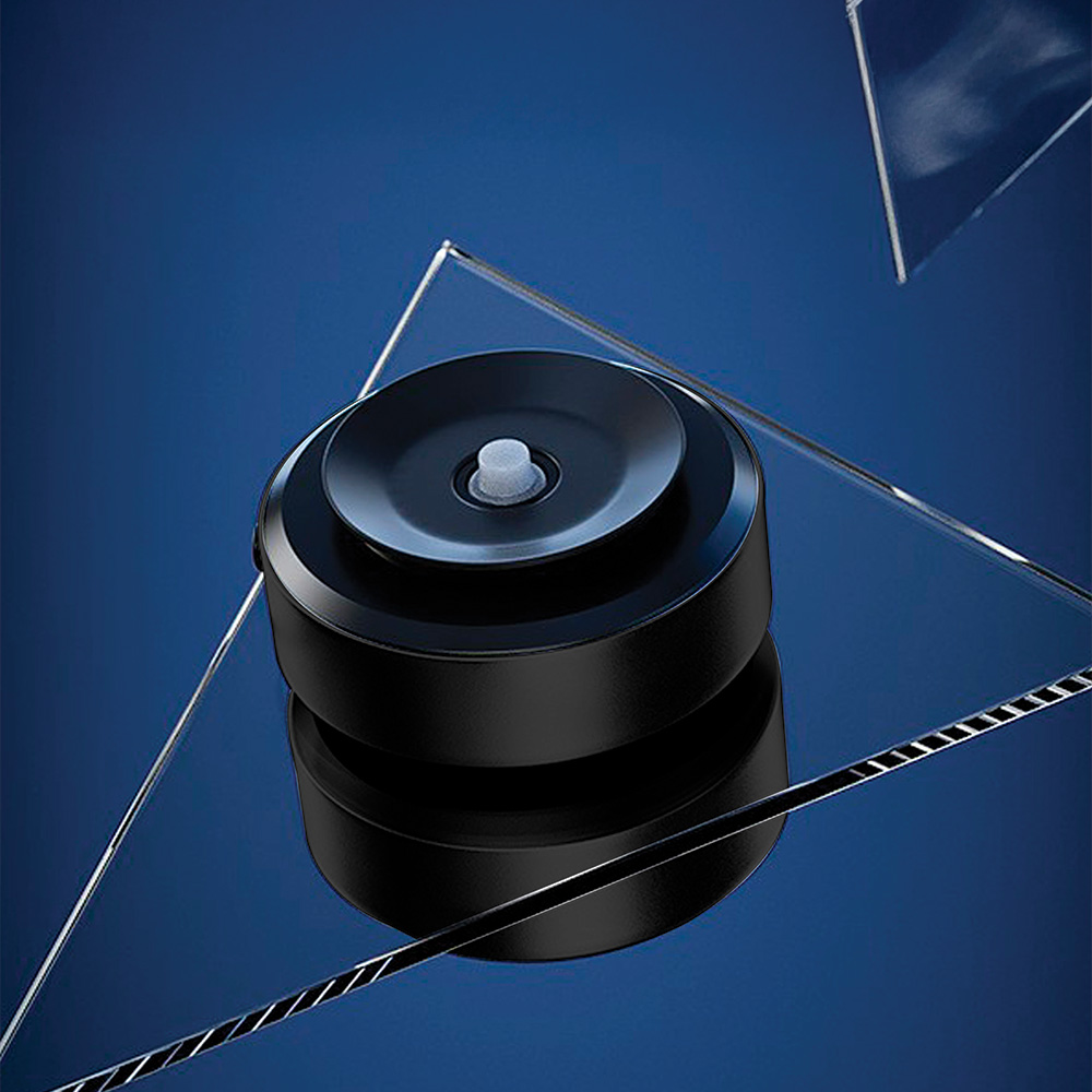 Beyaz merkezli siyah dairesel nesne, yansıtıcı bir yüzeyde duruyor. Arka plan, cam ve tel ile mavi.
