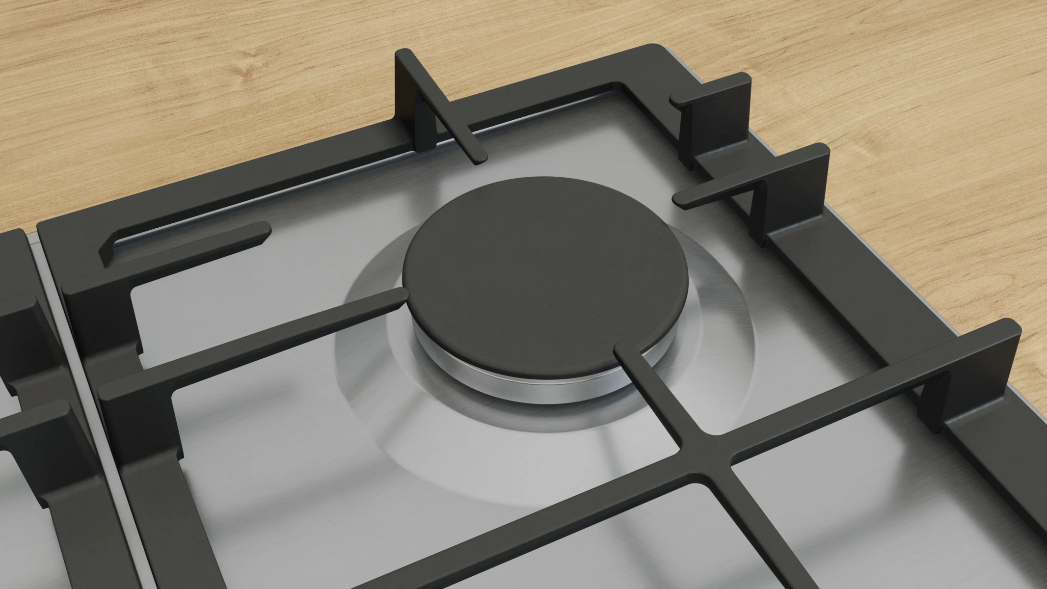Zbliżenie kuchenki gazowej. Czarne ruszty i palnik na srebrnej powierzchni. Jasny drewniany blat w tle.