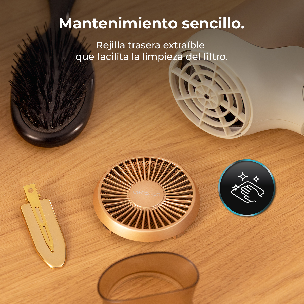 Herramientas para el cuidado del cabello sobre superficie de madera: secador, cepillo, pinza y ventilador dorado. Icono de limpieza visible.