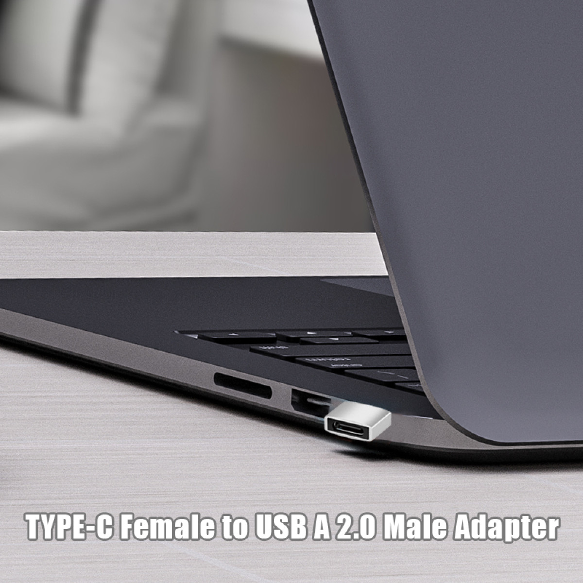 Adapter Type-C do USB jest podłączony do laptopa. Laptop jest szary, adapter srebrny. Tekst: TYPE-C Female to USB A 2.0 Male Adapter.