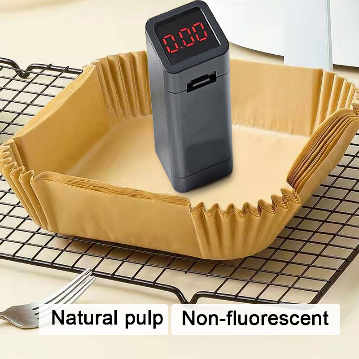 A digital kitchen scale displays 0.00. It stands on a black wire rack above a stack of brown paper baking cups.
