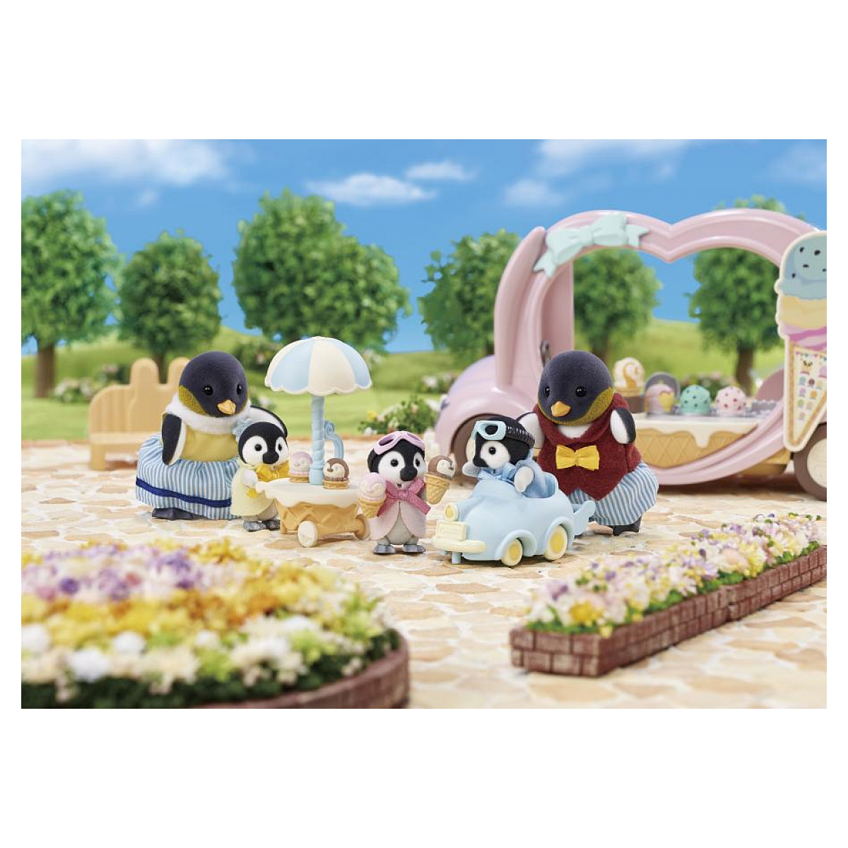 Familia de pingüinos en un puesto de helados. Varios pingüinos juegan con carritos de helados y un coche, en un parque con flores.