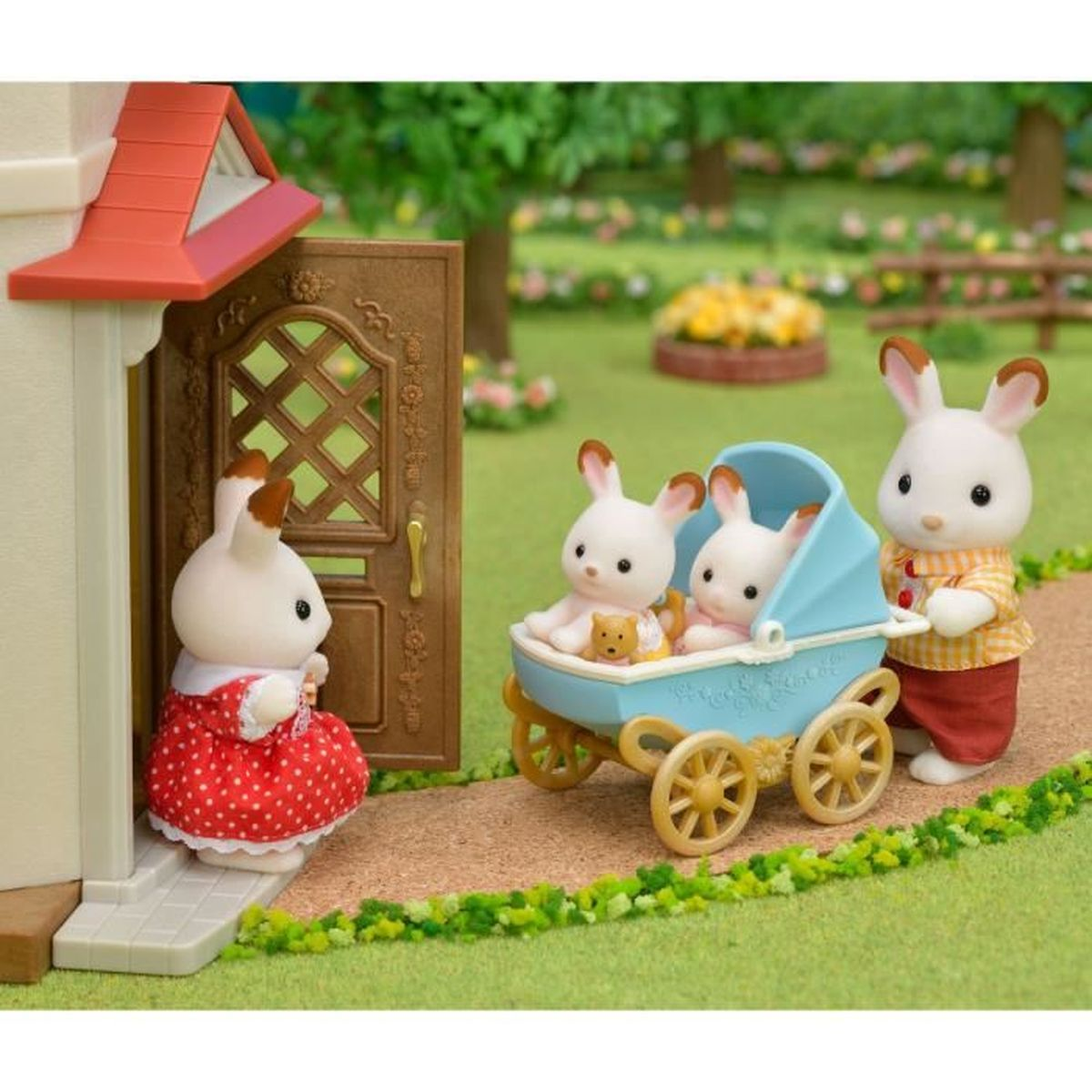 Figuras de conejos juegan afuera de una casa. Dos conejos están en un cochecito azul, otro está a su lado. Un conejo está junto a la puerta.