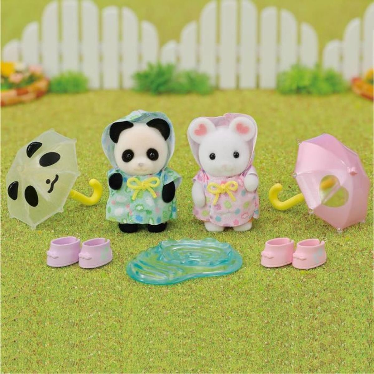 Escena con dos figuras de animales, panda y ratón, paraguas, botas y un charco. El fondo incluye una valla blanca y hierba verde.