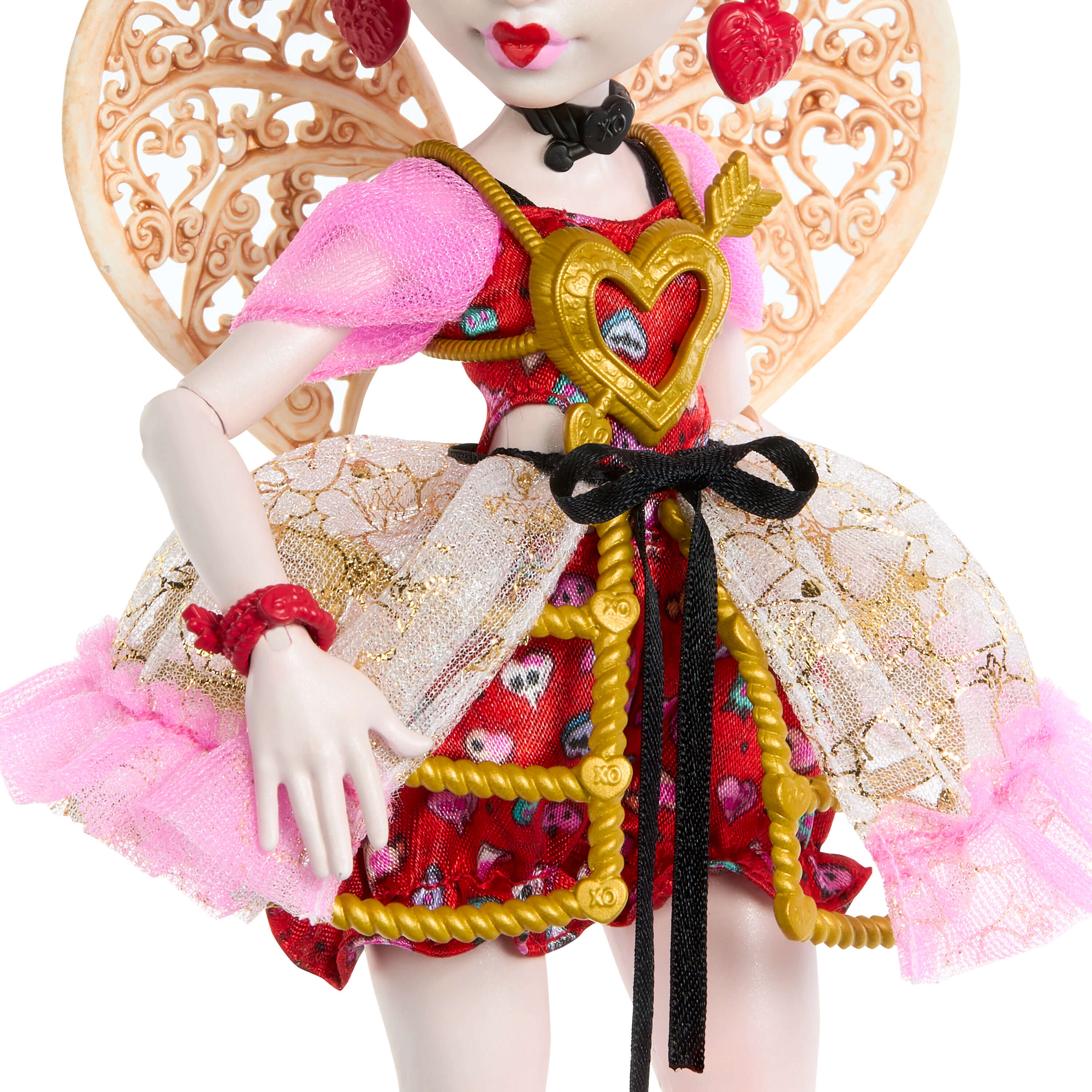 Una muñeca con pendientes en forma de corazón, alas y un vestido rojo y dorado.