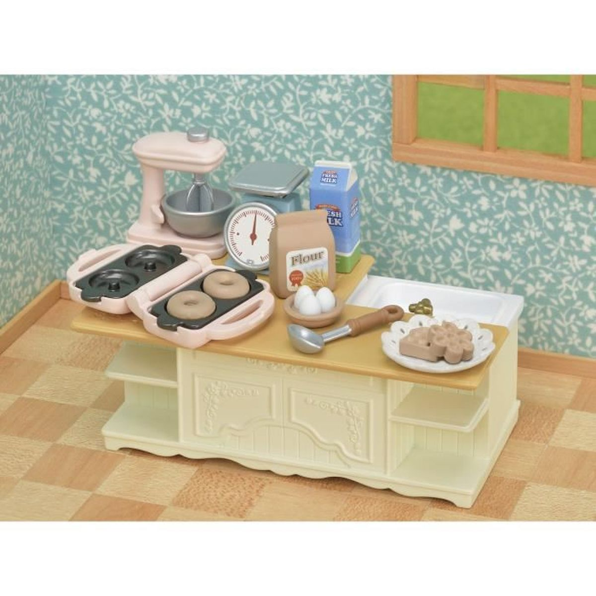 Una escena de cocina en miniatura con electrodomésticos de juguete. Incluye una batidora, balanza, donuts, harina, leche, huevos y gofres.
