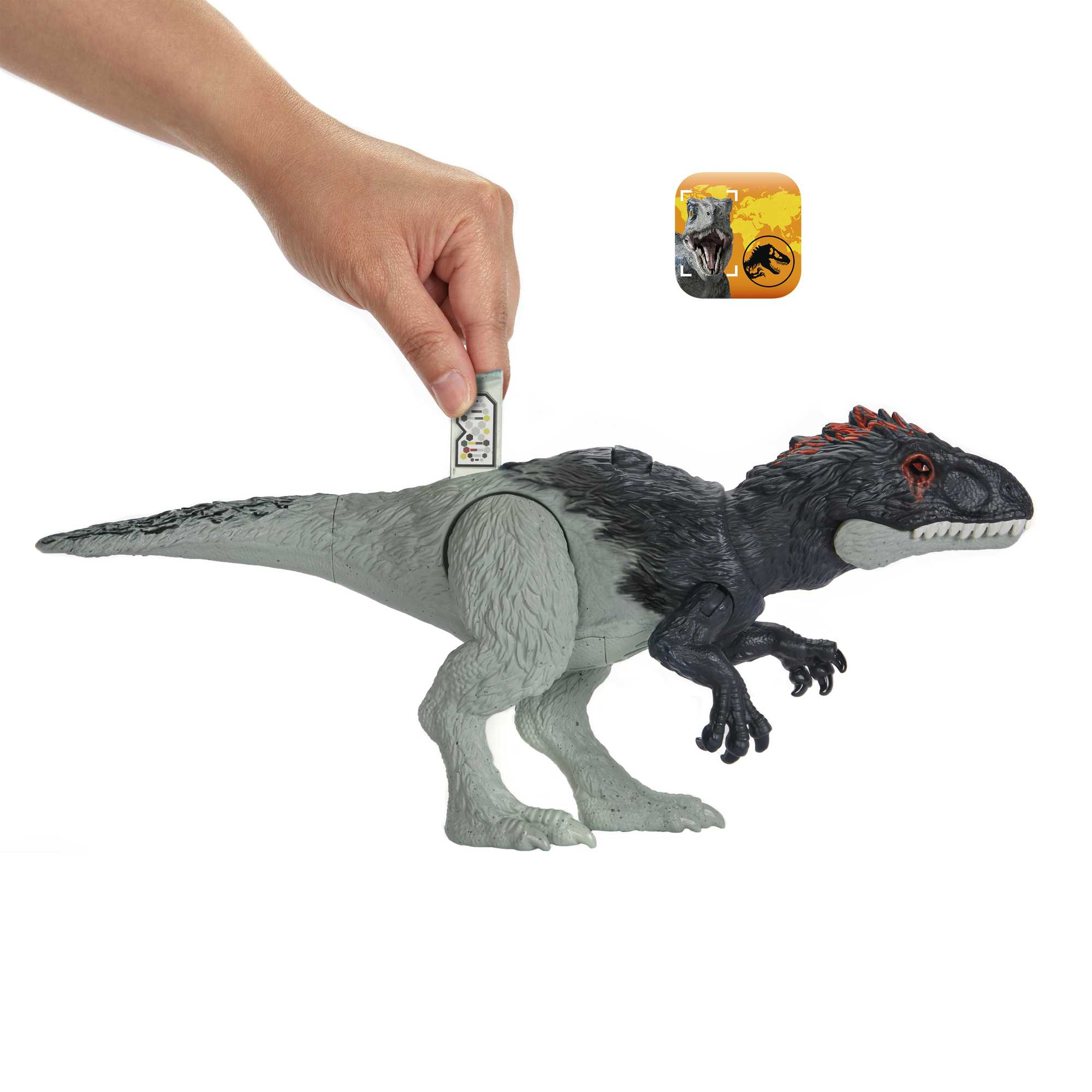 Una mano inserta una tarjeta en un dinosaurio de juguete. El dinosaurio es gris y negro y tiene detalles rojos.