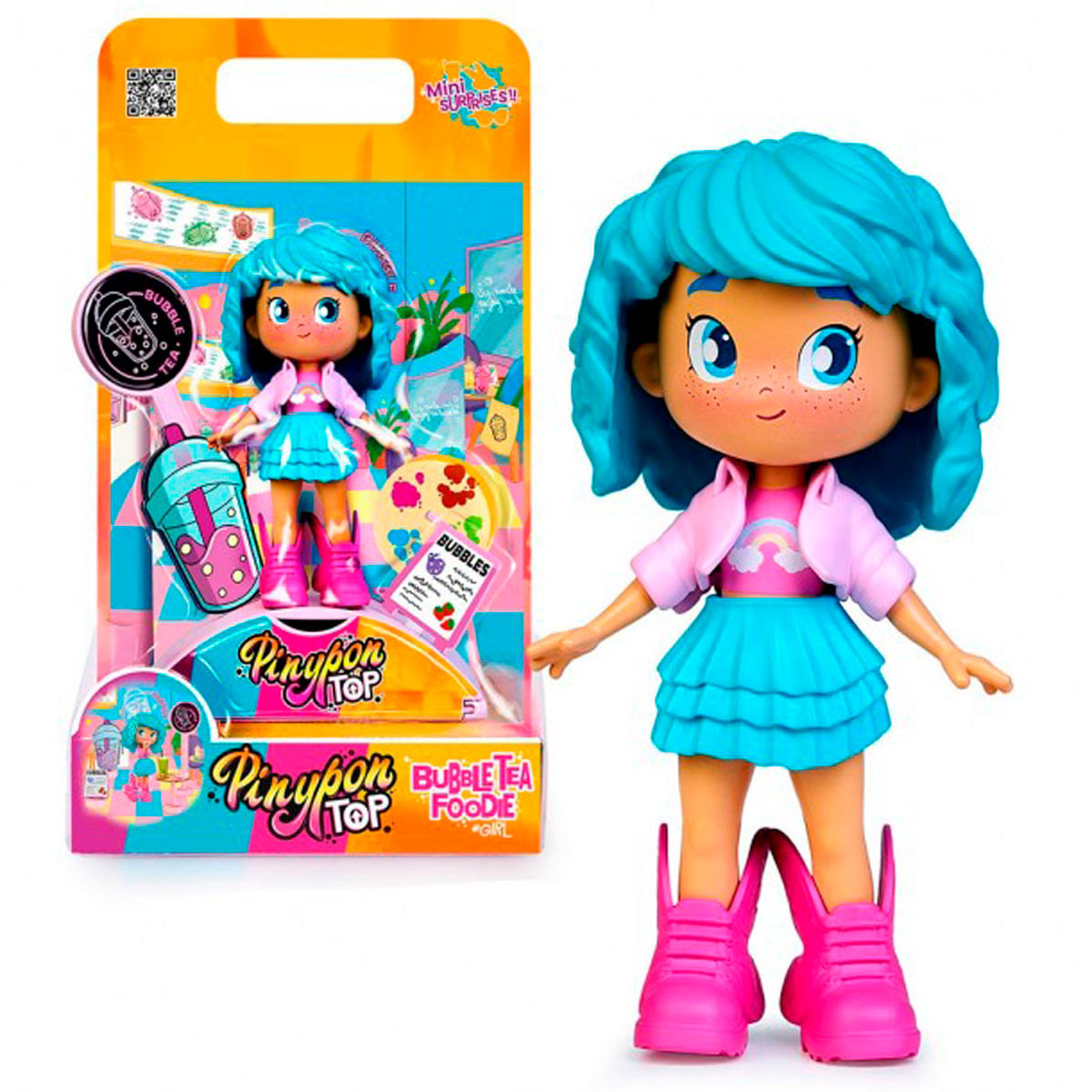 Una muñeca Pinypon con pelo azul y chaqueta rosa, junto a su caja. La caja tiene un diseño de té de burbujas con las palabras 'Bubble Tea Foodie Girl'.