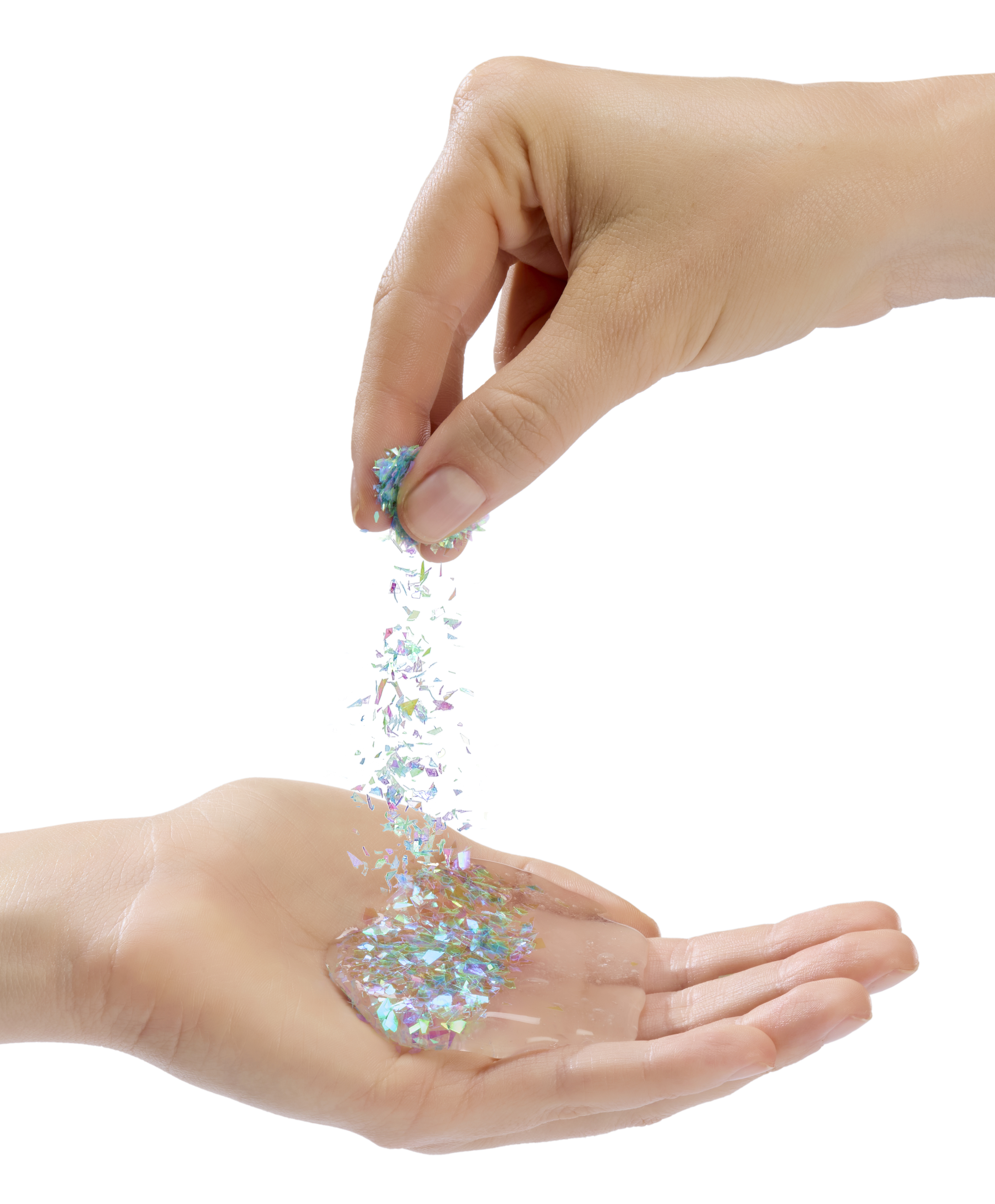 Dłoń wsypuje iryzujący brokat do drugiej otwartej dłoni, która zawiera przezroczystą, lepką substancję.