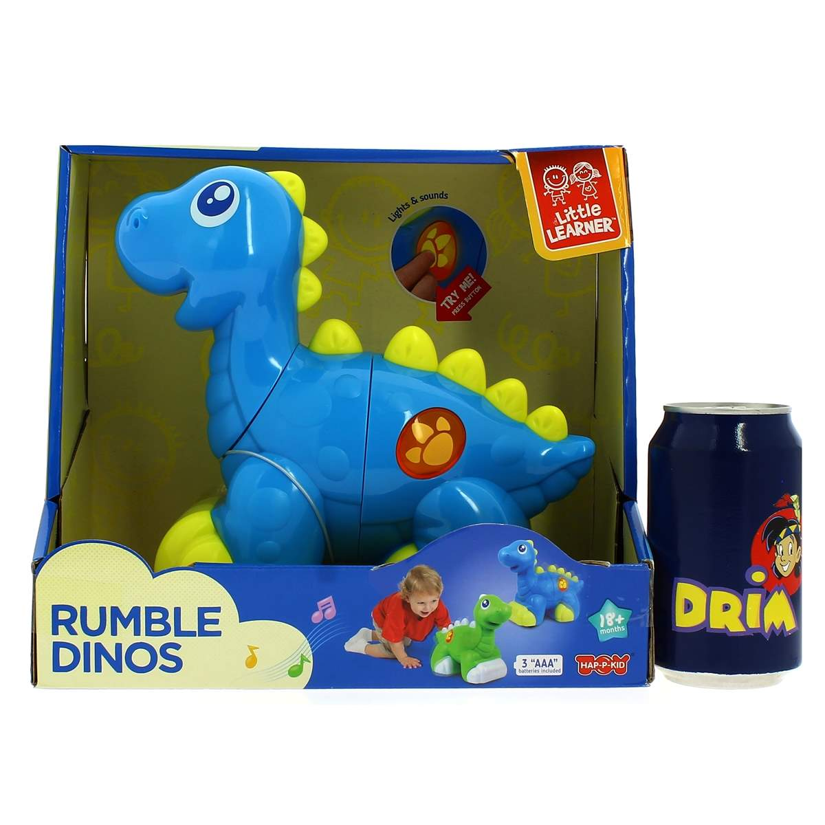 Un juguete de dinosaurio azul en una caja, con una lata de 'DRIA' al lado. El juguete se anuncia como 'Rumble Dinos' y 'Little Learner'.
