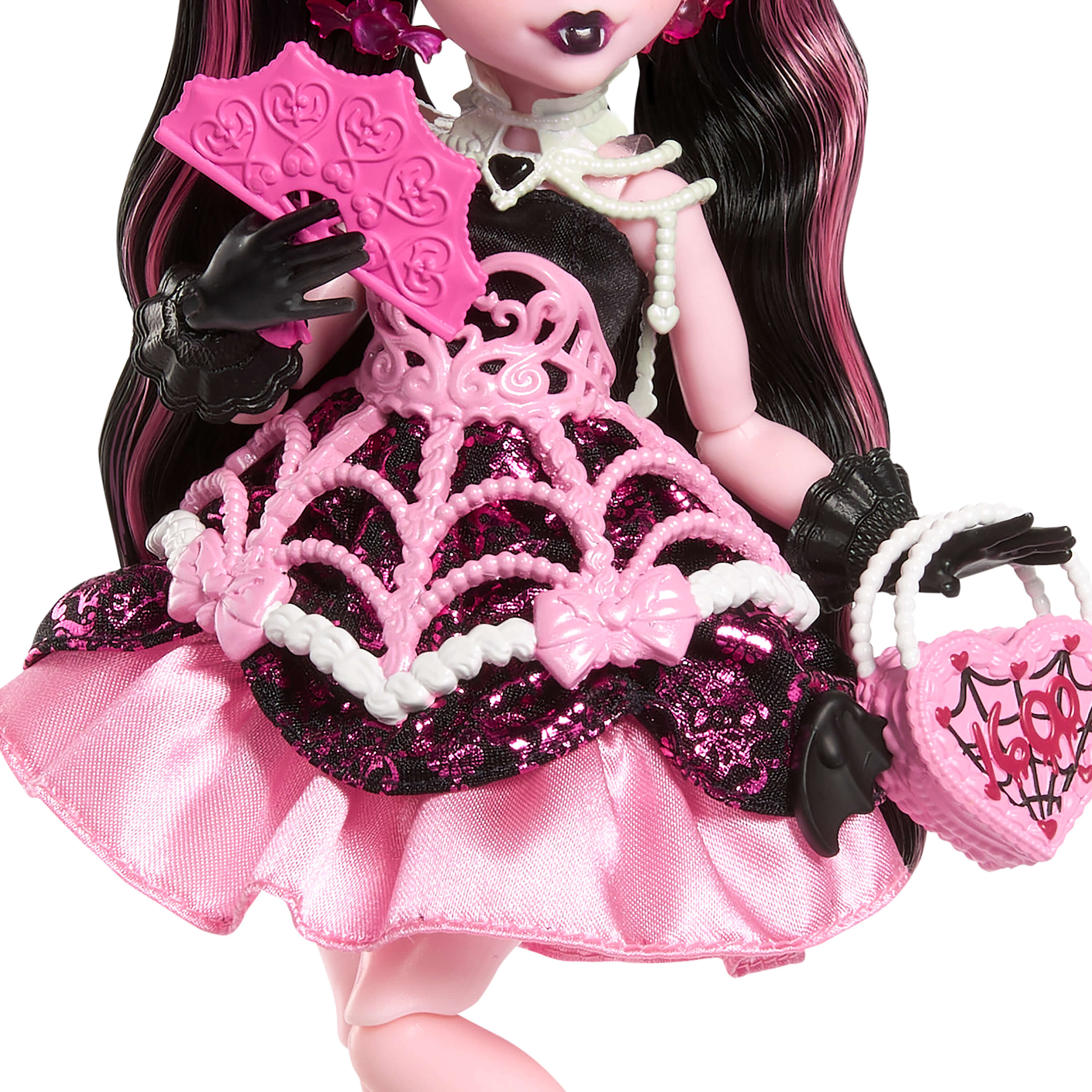 Muñeca con pelo negro y rosa, vestida con un vestido rosa, con un abanico y un bolso en forma de corazón.