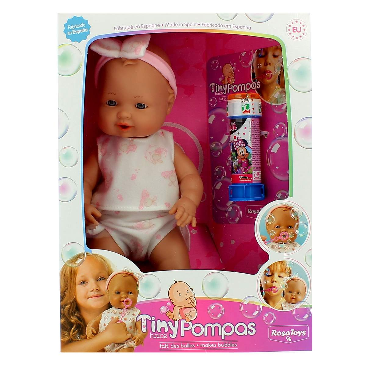 Una muñeca en una caja con un burbujeador. La muñeca tiene una diadema rosa y viste ropa blanca. La caja tiene imágenes de dibujos animados.