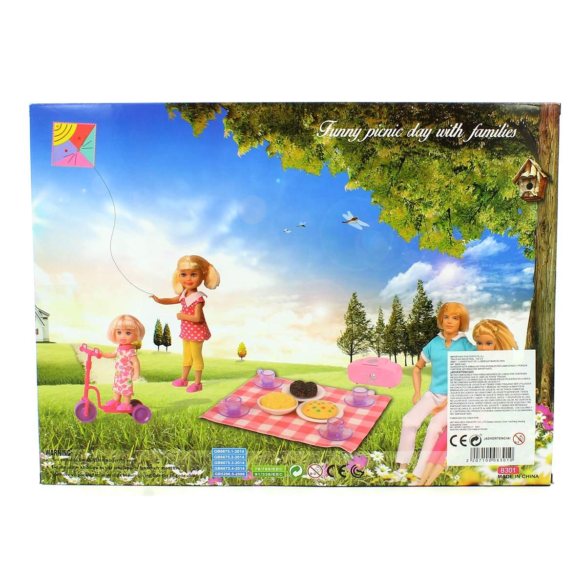 Una caja muestra muñecas en una escena de picnic. Una muñeca vuela una cometa. Otras muñecas están cerca de una manta de picnic con comida.